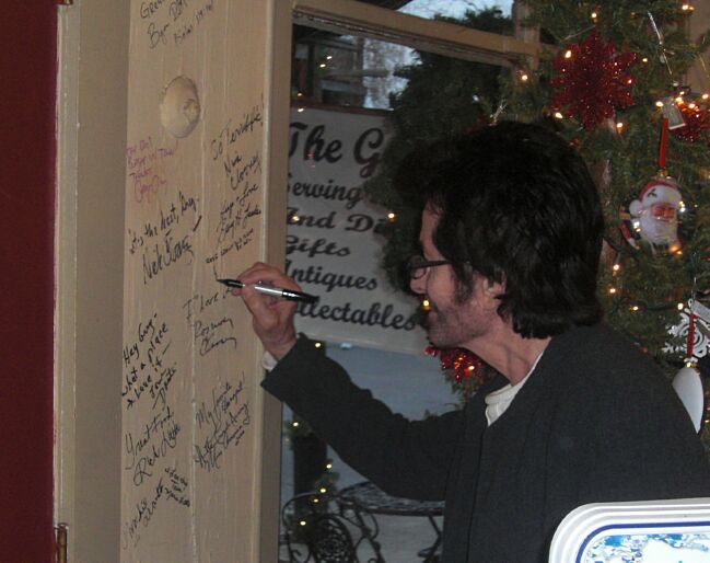 George signs the wall at the Old General Store 